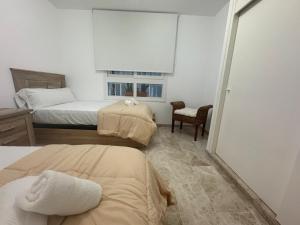 a bedroom with two beds and a window at Cozy Sunset in Almerimar