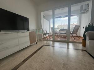 a living room with a television and a table with chairs at Cozy Sunset in Almerimar