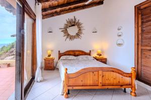 a bedroom with a wooden bed and two night stands at Casa Paradiso Guest House in Costa Paradiso