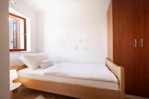 a bedroom with a bed with white sheets and a window at Apartment Klimno in Klimno
