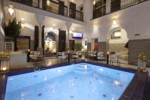 a large swimming pool in the middle of a building at Riad Atlas Dama in Marrakech