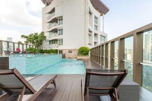 a swimming pool with two chairs next to a building at 2 BR in Downtown BTS Chitlom BKK in Bangkok