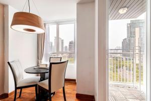a dining room with a table and chairs and a large window at 2 BR in Downtown BTS Chitlom BKK in Bangkok