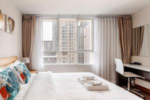 a hotel room with a bed and a desk and a window at 2 BR in Downtown BTS Chitlom BKK in Bangkok +41 photos