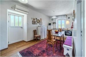 a kitchen with a table and a refrigerator in a room at Bunica house in Nerežišće