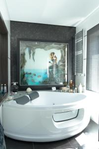 a bath tub in a bathroom with a painting on the wall at Royal Fraga do Douro in Vila Real