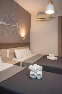 a hotel room with two beds with towels on them at Azzurro in Nei Poroi