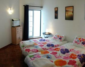 1 dormitorio con 2 camas y ventana en Casa Mar, en Tavira