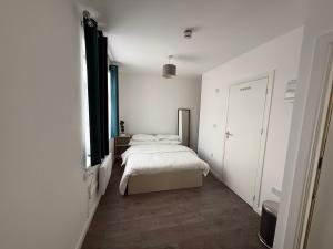 a small bedroom with a bed and a window at Comfy family studio in Goodmayes