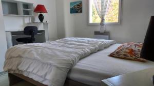 a bed in a bedroom with a desk and a window at La Belle Echappée in Champagnac