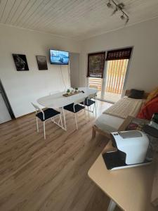 a living room with a white table and chairs at Bungalows Sonnenblume am Klopeiner See in Sankt Kanzian