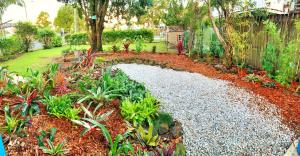 a garden with a stone path and plants at Bruns Beach Garden Apartment - Central, Comfortable & Close to the beach in Brunswick Heads