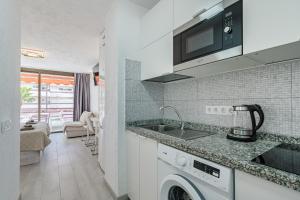 una cucina con lavello e lavatrice di Apartamentos Olympia a Playa de las Americas