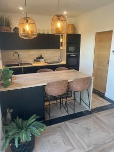 una cocina con una gran isla de madera con taburetes de bar en Villa vue sur Draguignan, en Draguignan
