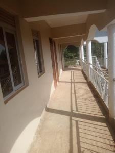an empty porch of a house with shadows on the side at Noaz Hotel in Bulambiro +21 photos