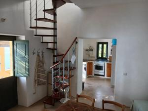 a spiral staircase in a living room with a kitchen at Casa al Vallone in Alicudi