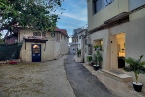 an alley with houses and a blue door at Ruth's Suites - סוויטות רות - 2 in Safed