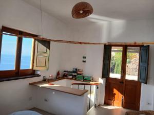 a kitchen with a sink and a counter with windows at Casa al Vallone in Alicudi