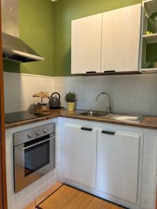 a kitchen with white cabinets and a sink at FILANGERI 116 in Santa Flavia