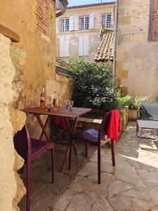 a wooden table and chairs on a patio at 140m2 du XVIIe, plein centre & extérieur, 6-9 pers in Bergerac
