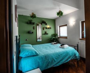 a bedroom with a blue bed with a green wall at Oasi Piacentina in Piacenza