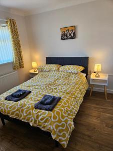 a bedroom with a bed with two towels on it at Greenways at Coed Cae Farm in Pontnewydd +75 photos
