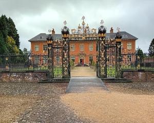 an entrance to a large building with a gate at Greenways at Coed Cae Farm in Pontnewydd