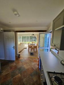 a kitchen with a table and a dining room at Greenways at Coed Cae Farm in Pontnewydd