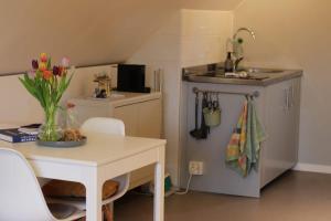 a small kitchen with a table and a sink at Stylish Guesthouse, City Access in Helsingborg