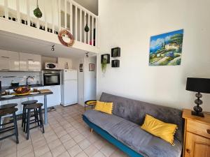 a living room with a couch and a kitchen at Bel appartement climatisé vu sur l'étang in Leucate-Plage +27 photos