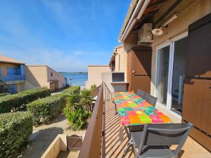a balcony with a table with a colorful blanket on it at Bel appartement climatisé vu sur l'étang in Leucate-Plage