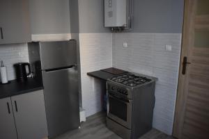 a small kitchen with a stove and a refrigerator at AGNESx in Przemyśl