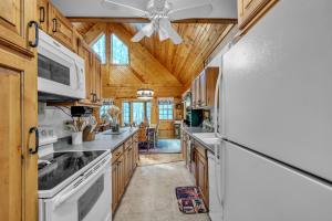 a kitchen with white appliances and a wooden ceiling at Woodlands Cabin Retreat in Oxford cabin in Oxford
