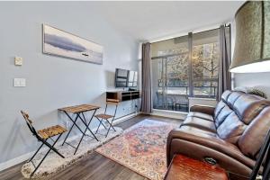 un salon avec un canapé et une table dans l'établissement Cozy 1 Bedroom Downtown Central, à Vancouver