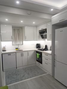 a white kitchen with white cabinets and a refrigerator at YoYo Apart in Dalaman