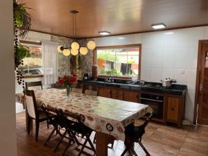a kitchen with a table and some chairs and a table and a kitchen at Refúgio em São Pedro da Serra in Nova Friburgo