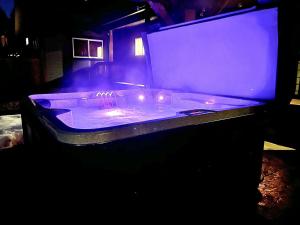 a hot tub with purple lights in a dark room at Mountain Retreat with Hot Tub, Game Room and Yard home in Ronald