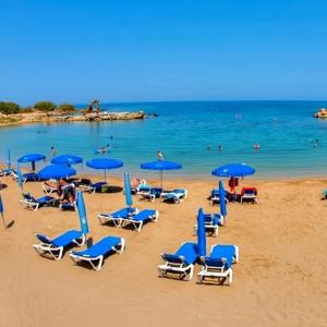 Un montón de sillas y sombrillas en una playa en Modern Holiday Appartment With Pool, en Paralimni 10 fotos más