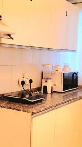 a kitchen with a counter top with a microwave and appliances at WeStay Ladies Hostel in Dubai +8 photos