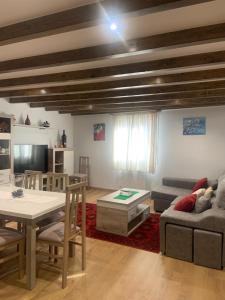 a living room with a table and a couch at Casa do Feligrés e da Alsira in Nogueira