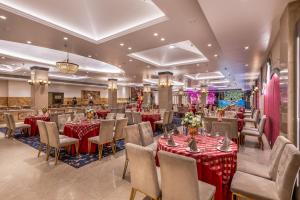 a restaurant with tables and chairs with red table cloths at Comfort Inn Alstonia in Amritsar