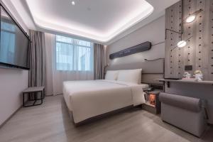 a bedroom with a large white bed and a tv at Atour X Hotel Guangzhou Zhujiang New Town Siyouxin Road in Guangzhou