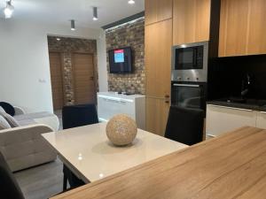 a kitchen with a table and a living room at Apartament z dwoma sypialniami i tarasem in Płock