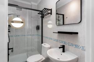 Un baño con inodoro, lavabo y espejo. en Casco antiguo terraza y vistas al mar Playa a Pie 1B, en Nerja 22 fotos más