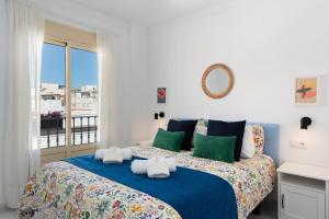 Un dormitorio con una cama grande con una manta azul. en Casco antiguo terraza y vistas al mar Playa a Pie 1B, en Nerja