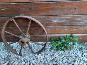 an old wooden wheel sitting on a pile of rocks at Roulotte de Camille, avec bain à remous in Winnezeele