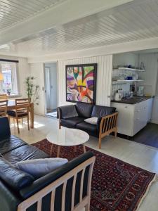 a living room with a couch and a table at Stokrosen in Åkirkeby
