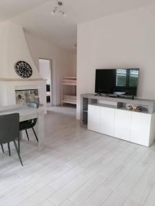 a living room with a tv and a table with a television at Villetta Relax Salvamary in Porto Torres