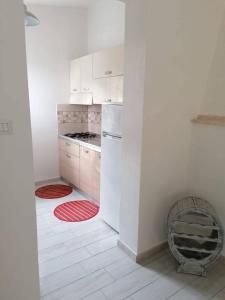 a kitchen with white cabinets and a stove top oven at Villetta Relax Salvamary in Porto Torres
