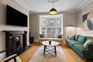 a living room with a couch and a fireplace at Stylish 7 Bedroom House in Plymouth